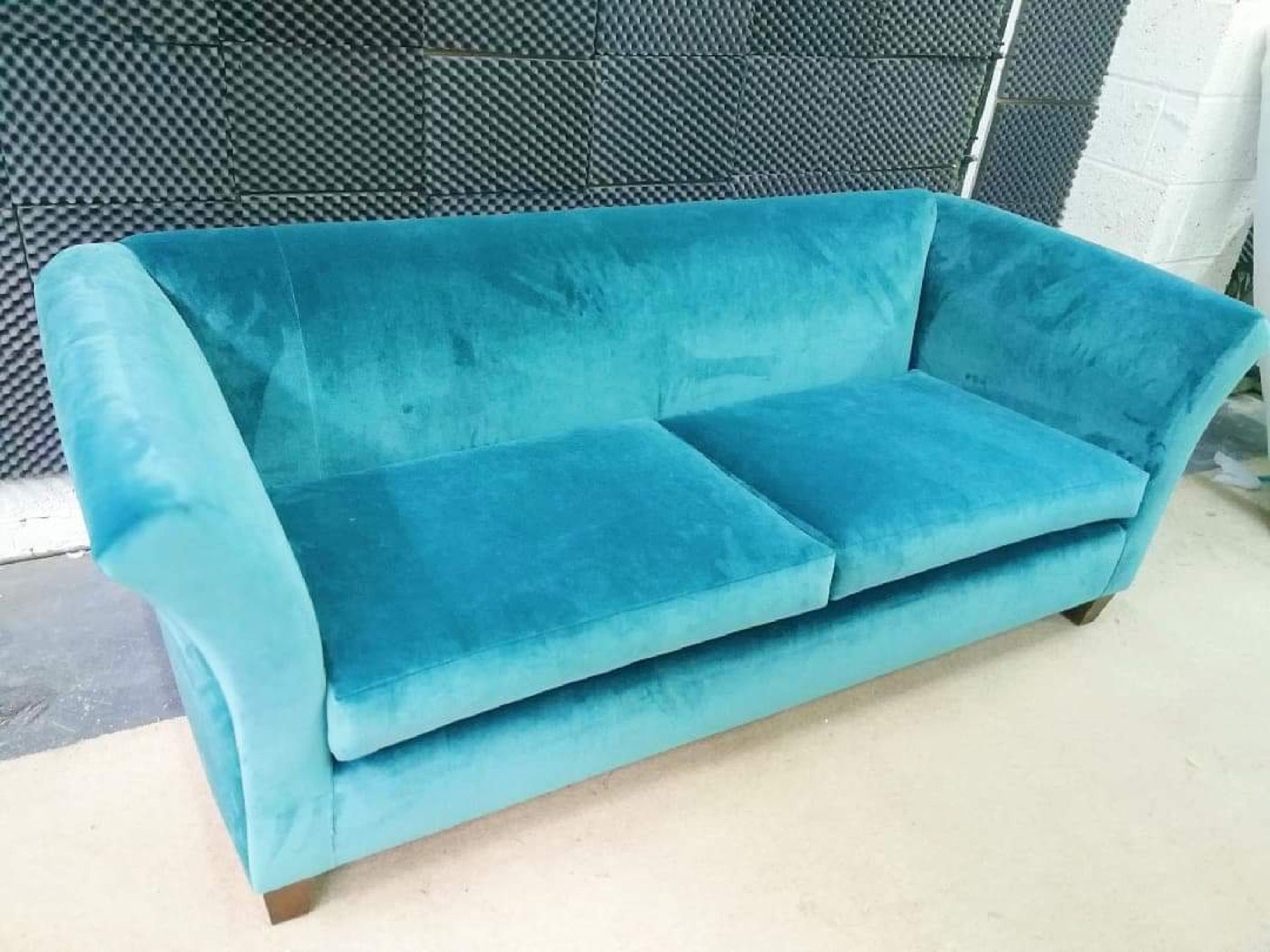 Turquoise velvet sofa after reupholstery in the workshop