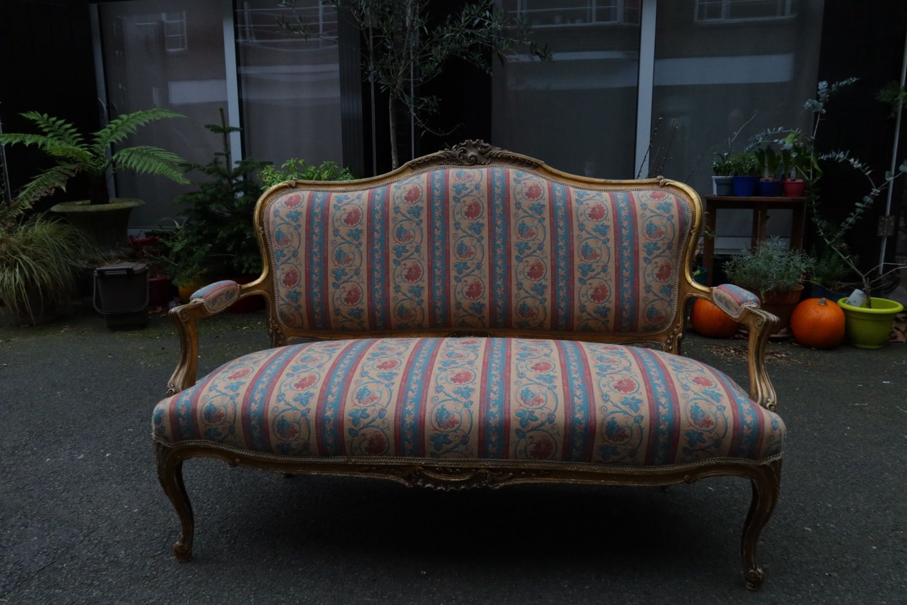 Vintage sofa with carved wooden frame and patterned upholstery