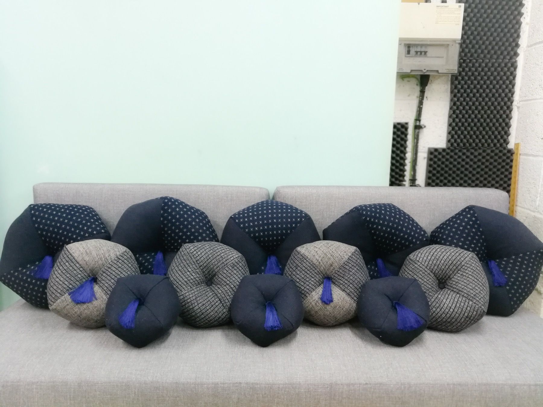 Close-up of woven upholstery button samples in grey and navy fabrics