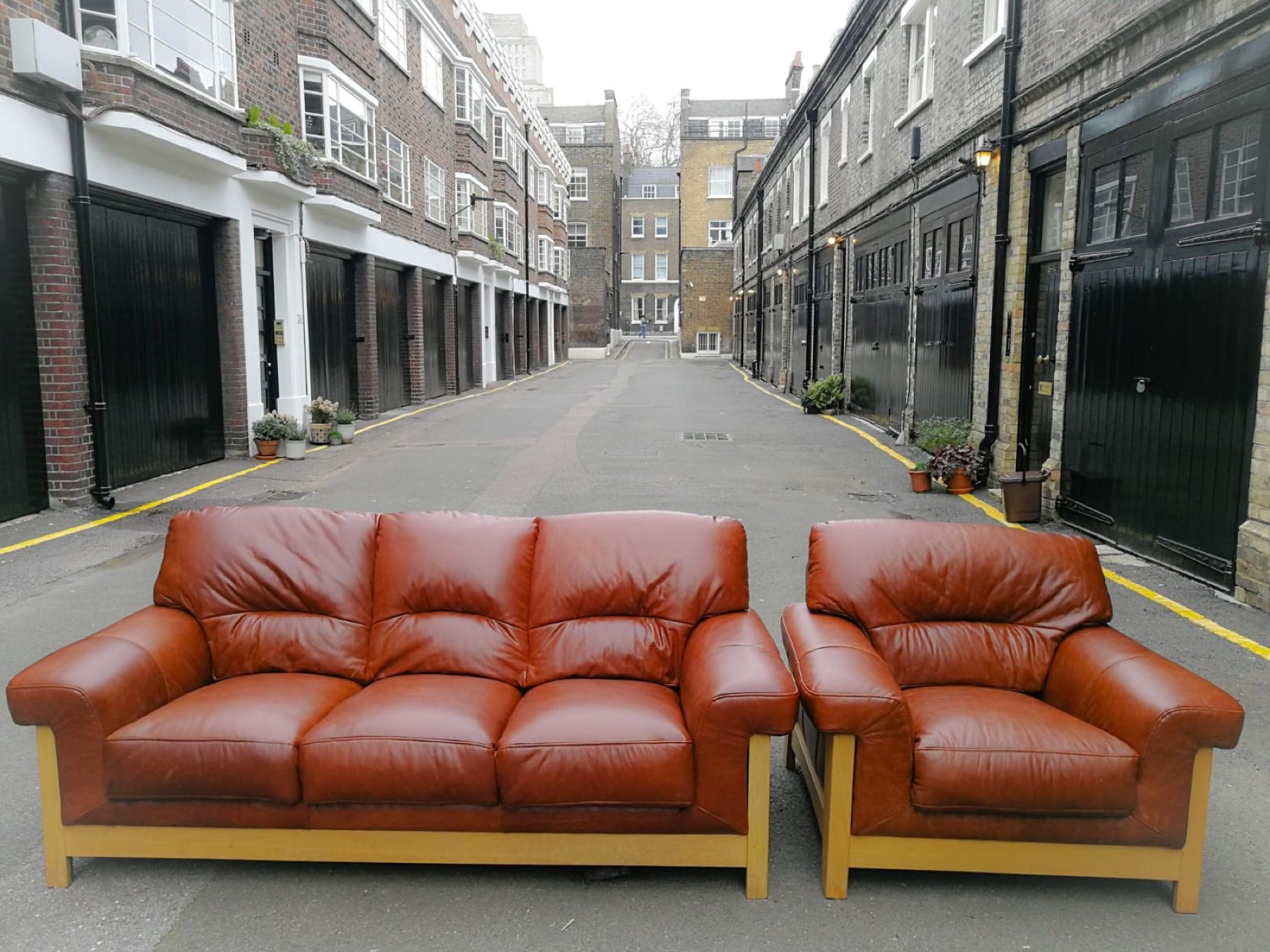 Brown leather sofa and matching armchair restored by Kennington Upholstery in London