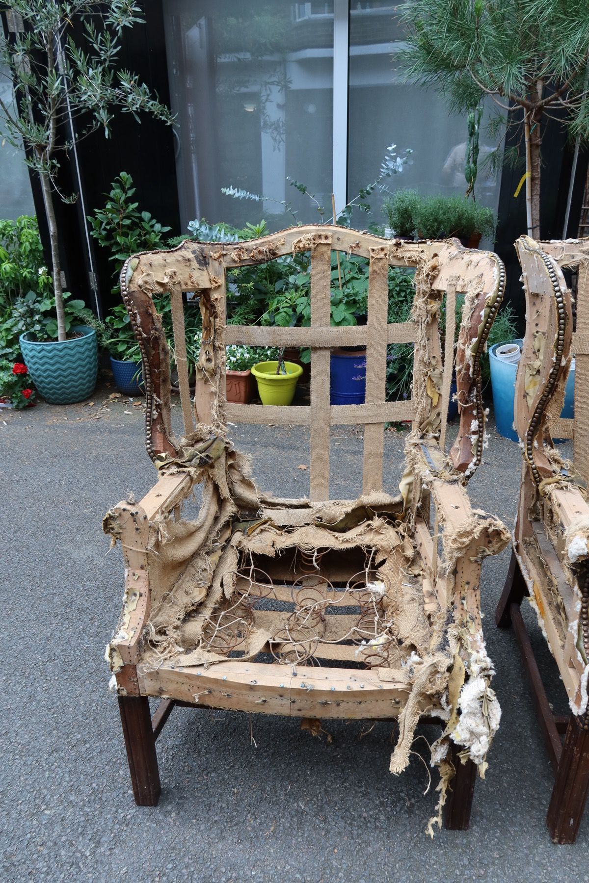 Stripped chair frame with exposed springs and webbing ready for upholstery inspection
