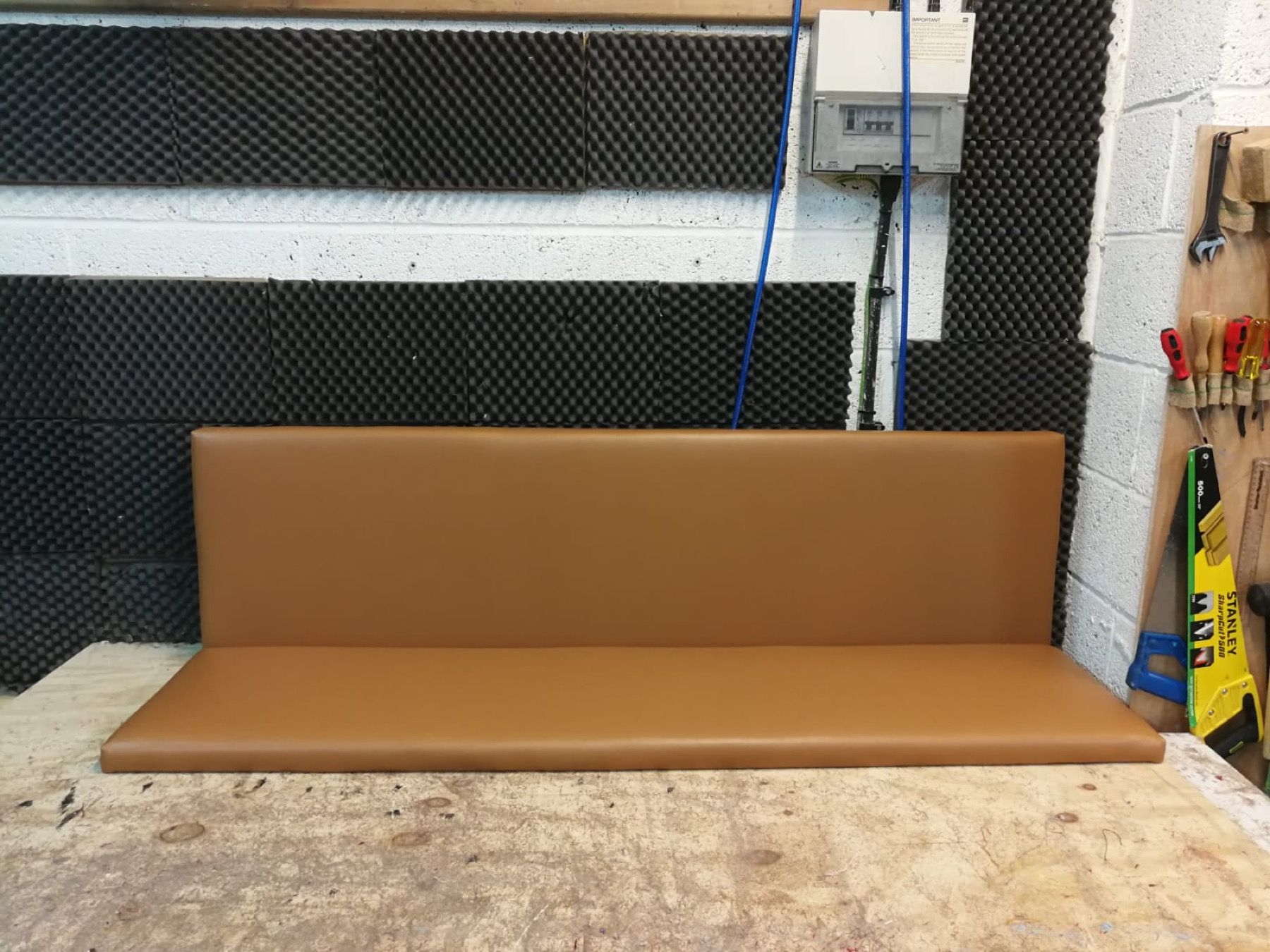 Finished brown upholstered restaurant bench for a New Oxford Street project