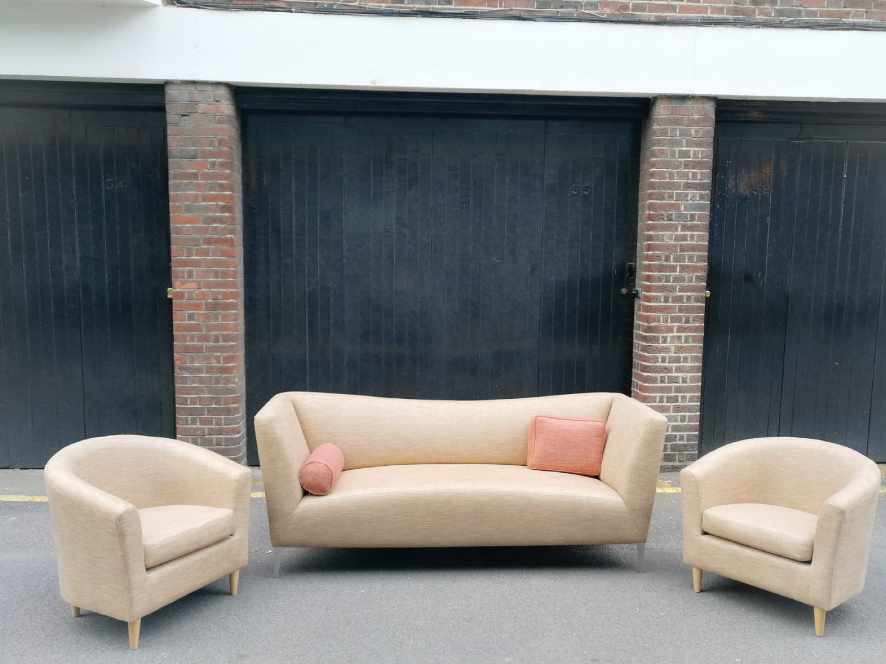 Finished cream sofa and matching chairs photographed outside the upholstery workshop