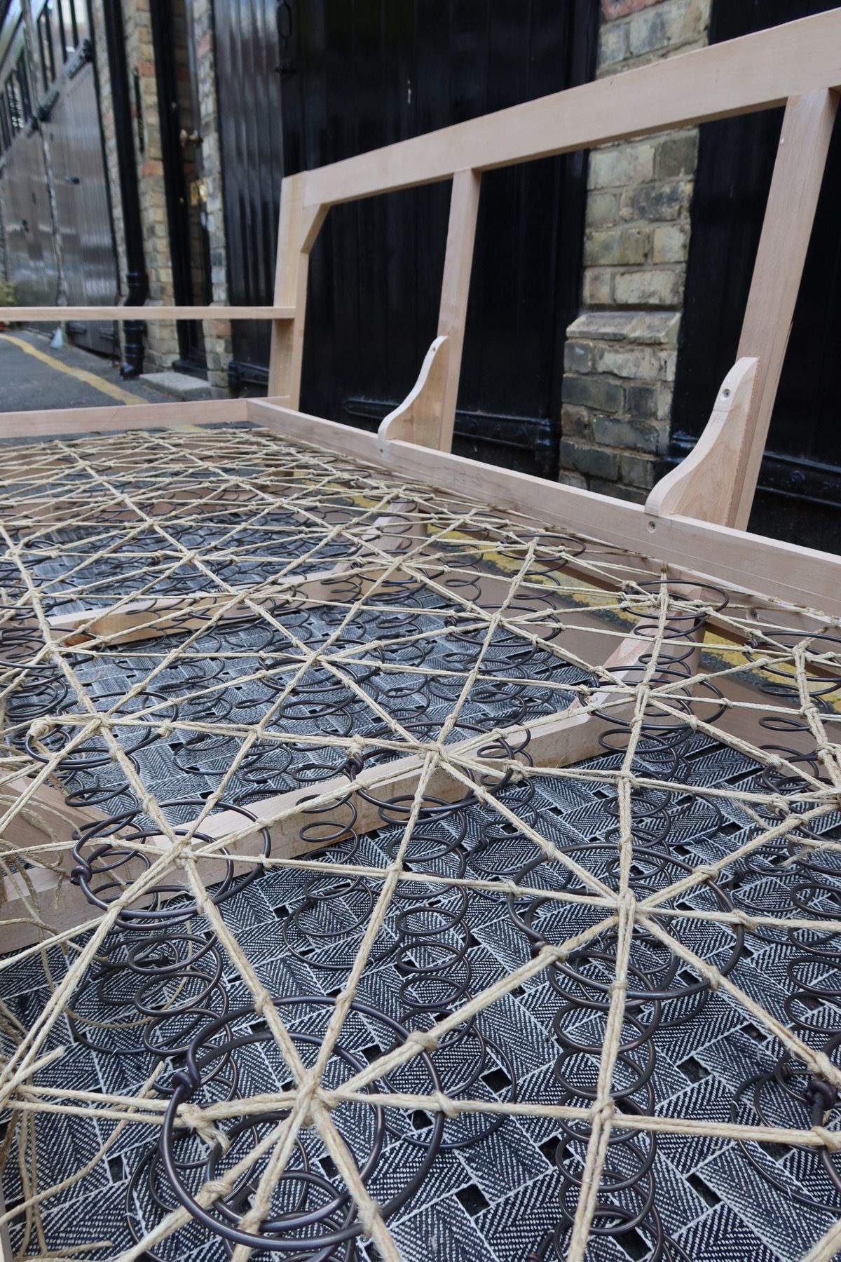 Hand-tied springs and webbing on a new upholstery frame in a London workshop