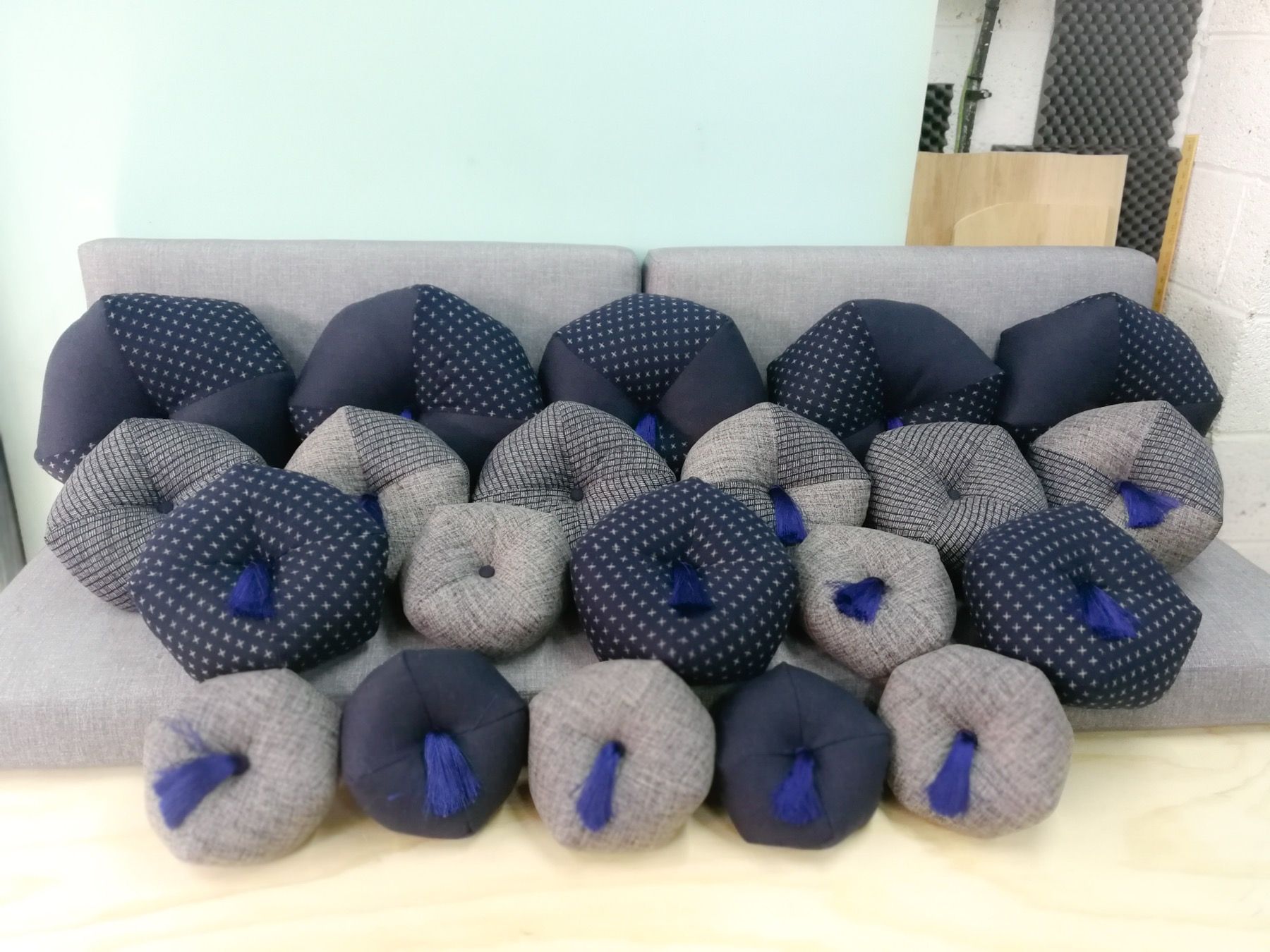 Old sofa cushions laid on new blue foam ready for cushion refilling