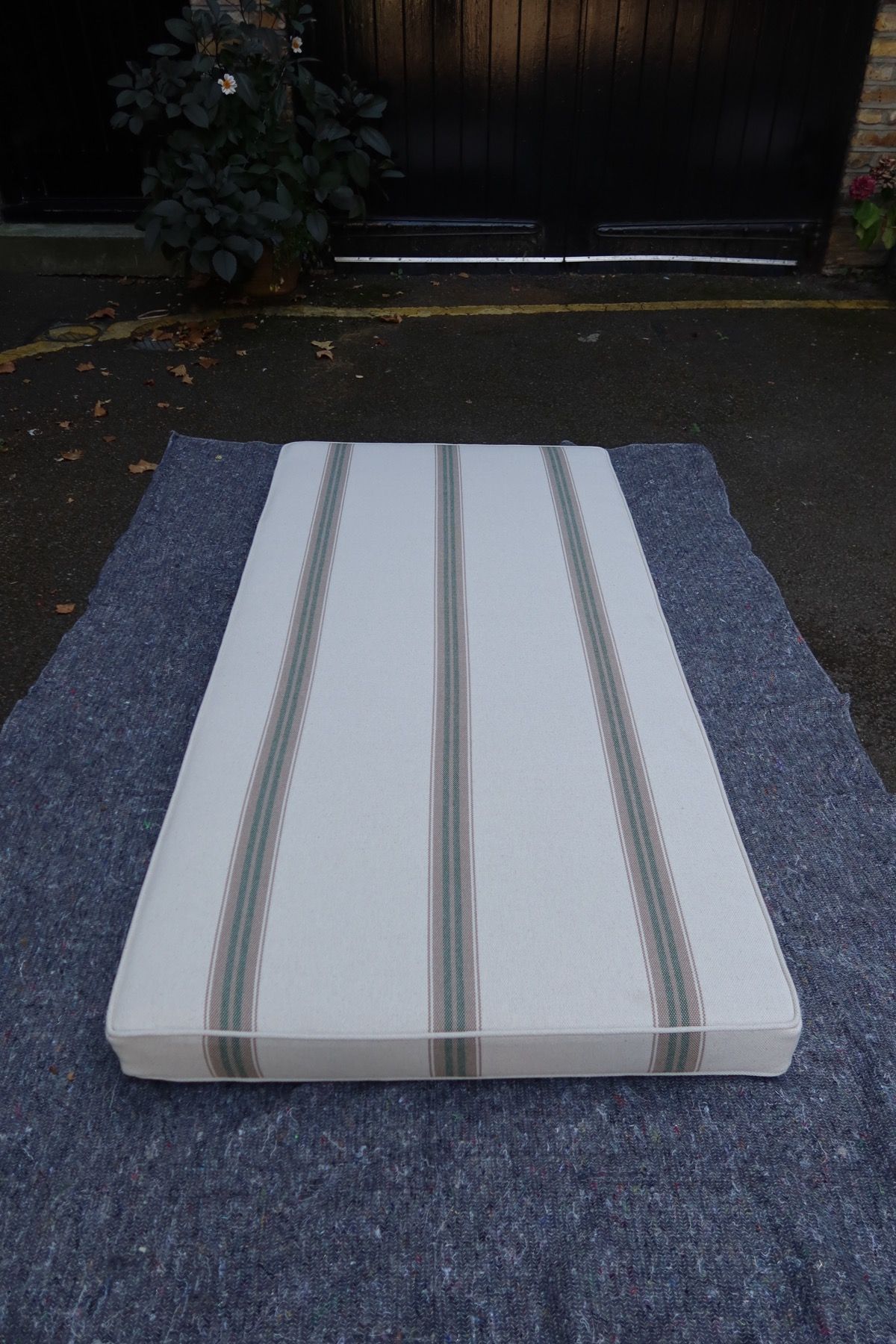 Angled view of a striped box cushion showing piping and cushion depth